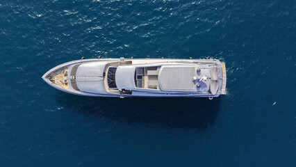 Aerial drone photo of luxury yacht with wooden deck anchored in Aegean island deep blue bay © aerial-drone