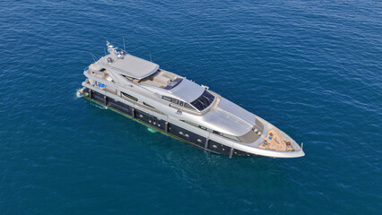 Aerial drone photo of luxury yacht with wooden deck anchored in Aegean island deep blue bay © aerial-drone
