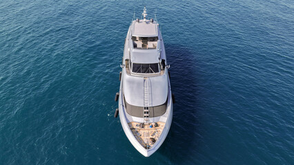 Aerial drone photo of luxury yacht with wooden deck anchored in Aegean island deep blue bay © aerial-drone