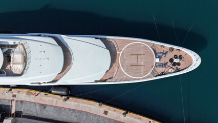 Aerial drone top down photo of luxury yacht with wooden deck and helipad anchored in tropical exotic island port © aerial-drone