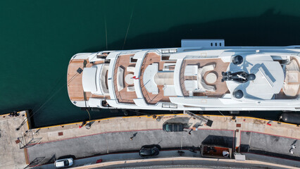 Aerial drone top down photo of luxury yacht with wooden deck and helipad anchored in tropical exotic island port © aerial-drone