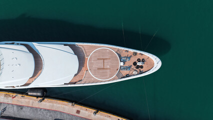 Aerial drone top down photo of luxury yacht with wooden deck and helipad anchored in tropical exotic island port © aerial-drone