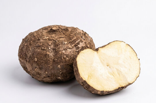 Fresh Elephant Foot Yam Whole and Halved Showing White Flesh on White Background