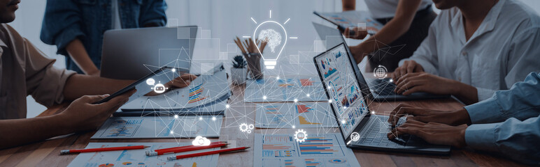 A diverse team collaborates during a brainstorming session, utilizing laptops and digital tools to...