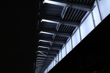 at night, under the steel span of the bridge, artificial lighting, low angle of view