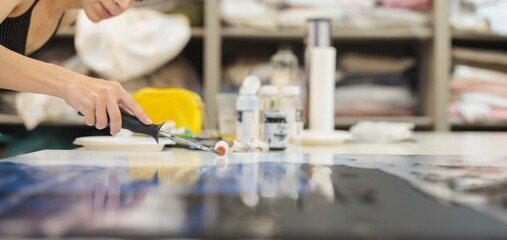 An artist passionately applies paint to a large canvas, showcasing their unique style in a spacious studio filled with art materials and bright colors, capturing creativity in motion
