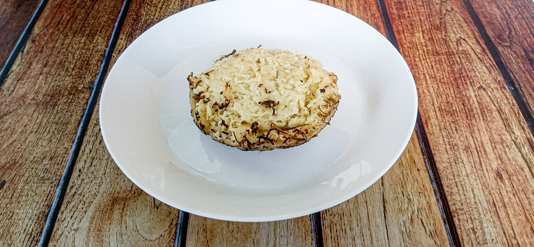 Cheese-flavored grilled serabi served on a white plate. Brown background.