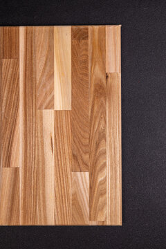 Wooden cutting board on black textured surface