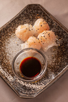 Har gow or ha cao close-up, shrimp dumplings served on a plate. The translucent steamed dumplings are part of traditional Cantonese dim sum cuisine. The dish is presented in a dining setting.