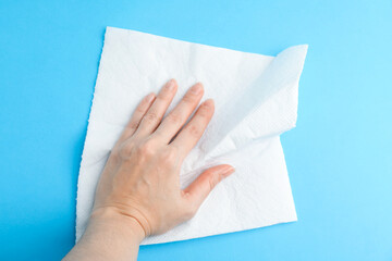 Woman with paper towel on light blue background, top view