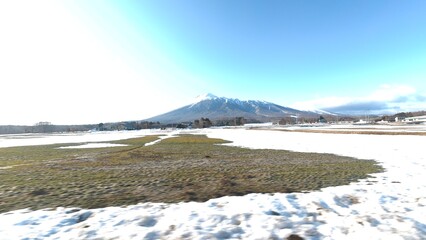 雪解けが始まった牧草地と岩手山 © あら～んどろ～ん