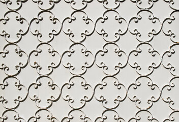 Obraz premium Ornamental detail of a painted beige metal gate pattern texture.