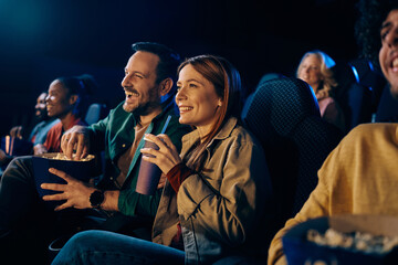 Happy couple watching movie in theater.