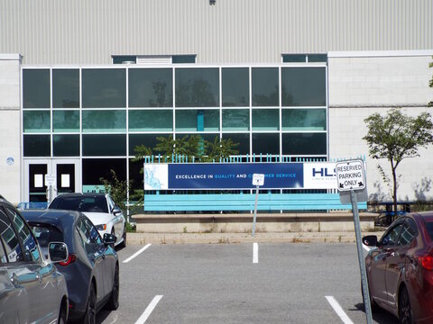 Ottawa, Ontario, Canada-July 17, 2025: An "HLS Linen Services" building features blue branding and a slogan sign behind a parking lot at  45 Gurdwara Rd.
