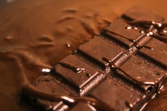 close up of chocolate bar on top of melted chocolate