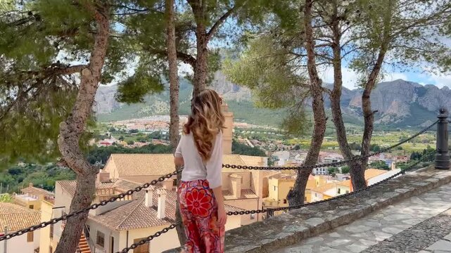 Mujer subiendo calle del Castillo con pueblo y monta&ntilde;as Polop