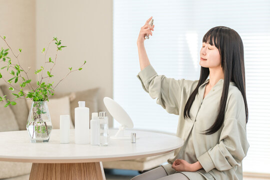 Asian woman doing skin care with spray lotion