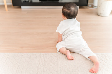Naklejka premium Baby crawling in the living room at home