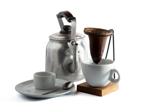 Classic Brazilian manual coffee brewing set with rustic kettle and cup on white background
