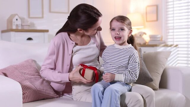 Happy Mother's Day. Little girl greeting her mom with gift box indoors