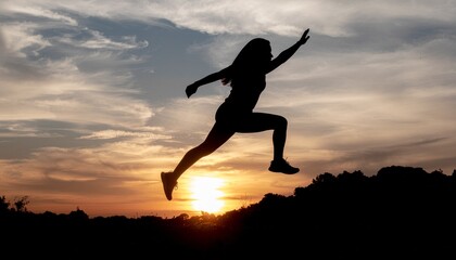 Fototapeta premium Silhouette of a woman jumping against a vibrant sunset, symbolizing fitness and active living