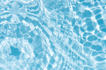 Obraz premium Blue water with ripples on the surface. Defocus blurred transparent blue colored clear calm water surface texture with splashes and bubbles. Water waves with shining pattern texture background.