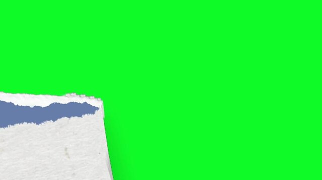 Horizontal paper tear effect revealing a green screen background from the center of a blue textured paper surface area smoothly
