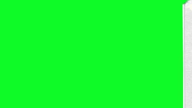 White paper material being torn away diagonally to reveal a bright green screen chroma key background for creative video transitions