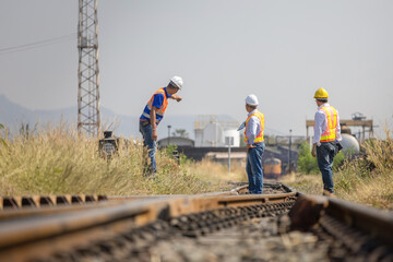 Asian railway engineers surveying railroad tracks and infrastructure project at site, Group of...