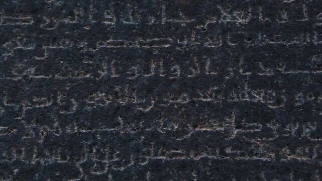 Ancient stone tablet with carved inscriptions, close-up detail of weathered text