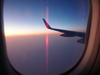 Airplane wing soaring through vibrant sunset skies