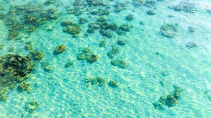 Top view of natural coral formations in shallow sea water with rippling sun reflections, perfect for summer vacation, snorkeling, and environmental conservation themes. concept environment lagoon. © Media 