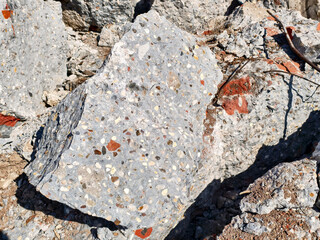 Unique texture and composition of exposed concrete and aggregate at a construction site during daylight
