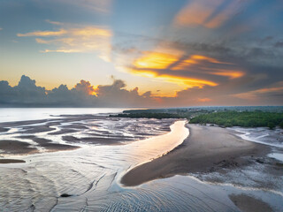 The beautiful colors at sunrise create a peaceful atmosphere, and the reflection of light on the river near the estuary adds to the vibrant morning ambiance © HeinrichDengi