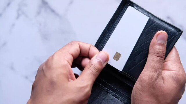 Person holding open a wallet with a white card inside