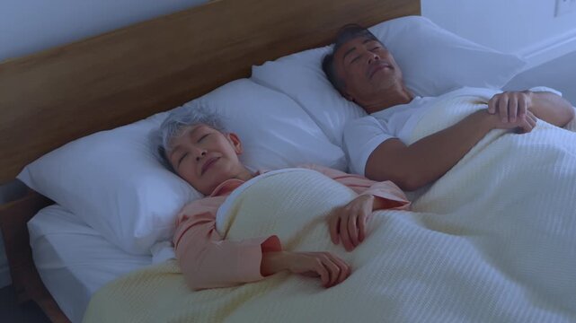 ベッドで眠るシニア夫婦　ライフスタイルイメージ