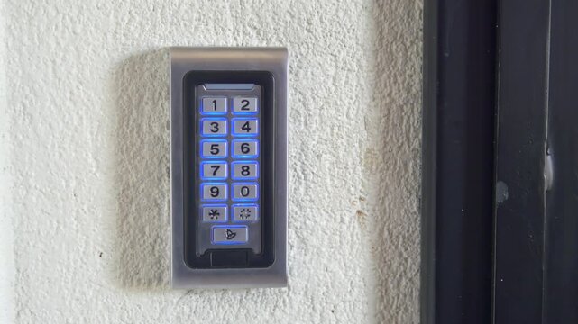 Close-up of a person entering a code on a digital keypad access control system, a modern security measure for doors and buildings