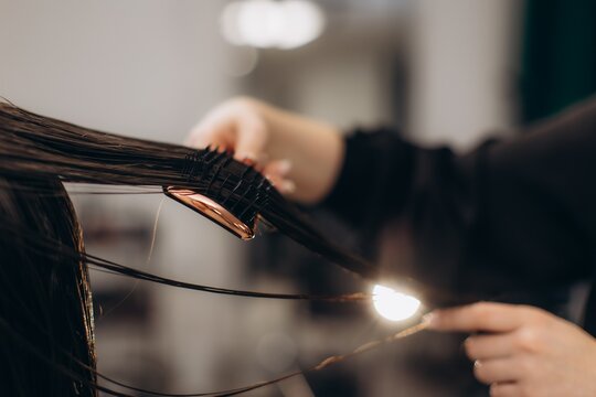 Hairdresser brushing wet hair with a styling brush