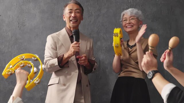マイクを持って歌を歌うシニア男女　ライフスタイルイメージ