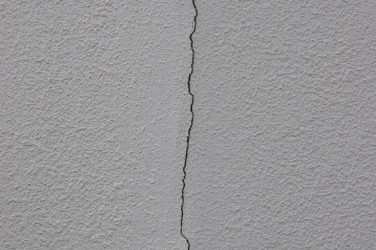 縦に亀裂が入っている白い外壁