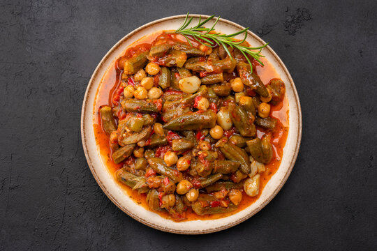 Freshly cooked okra dish on black stone table background