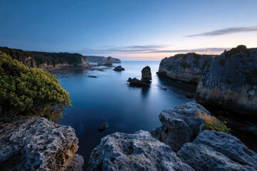 A stunning view of waves crashing against rocky formations during sunset, showcasing the dynamic beauty of coastal landscapes and the power of nature.