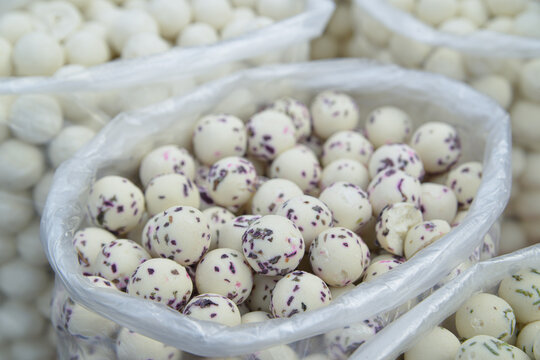 White and colored milk balls in bags are the national Uzbek dairy dish kurt. curd mass dried to the state of stone, mixed with spices and herbs, rolled into a ball
