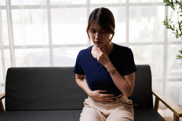 Obraz premium Young Asian Woman Touching Throat Suffering from Sore Throat at Home 