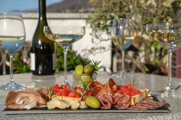 Food antipasto prosciutto ham, salami, olives and grissini bread sticks. cheese on a board...