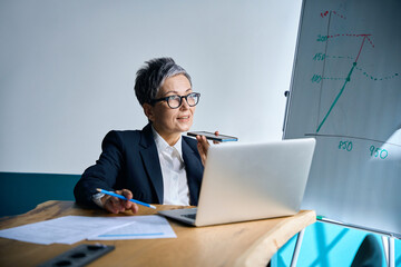 Focused woman speaking on phone in office during daytime