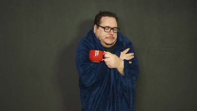 Young man with glasses wipes his nose with a white napkin. 