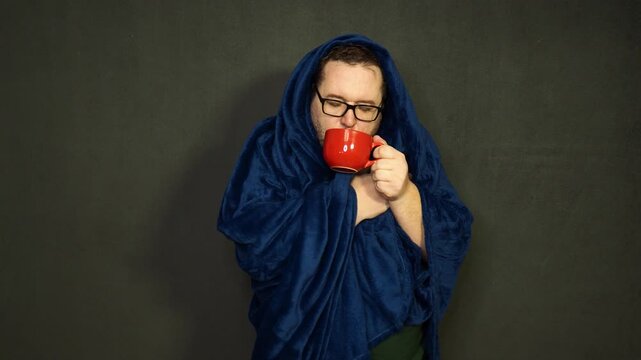 Young man with glasses wipes his nose with a white napkin. 