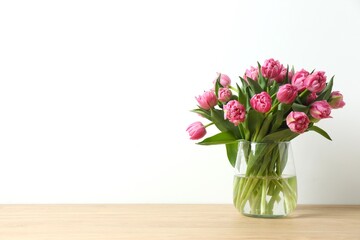 Beautiful pink peony tulips in a vase on wooden table © Sunlight