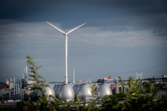A wind turbine in Hamburg, Germany, with a cloudy blue sky in the background.